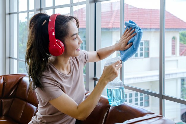 Le donne puliscono la casa con vestiti e liquidi.