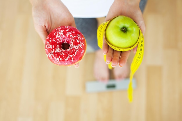 Le donne scelgono tra la ciambella e la mela verde durante la sua sessione di dieta.