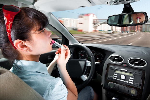 le donne si truccano le labbra al volante della macchina