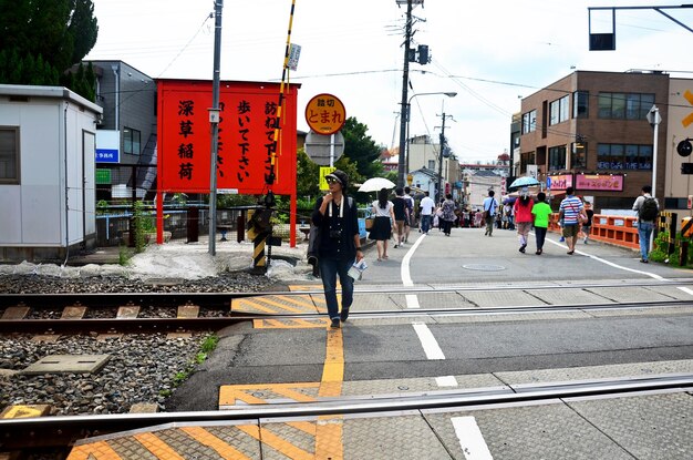 Le donne tailandesi del viaggiatore che camminano su strada cossover del treno ferroviario vanno al santuario di Fushimi Inari Taisha l'11 luglio 2015 a Kyoto in Giappone