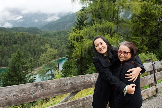 Le donne tailandesi, madre e figlia, viaggiano e posano con vista sul paesaggio della foresta e Blindsee è un lago sulla montagna del Tirolo Austria