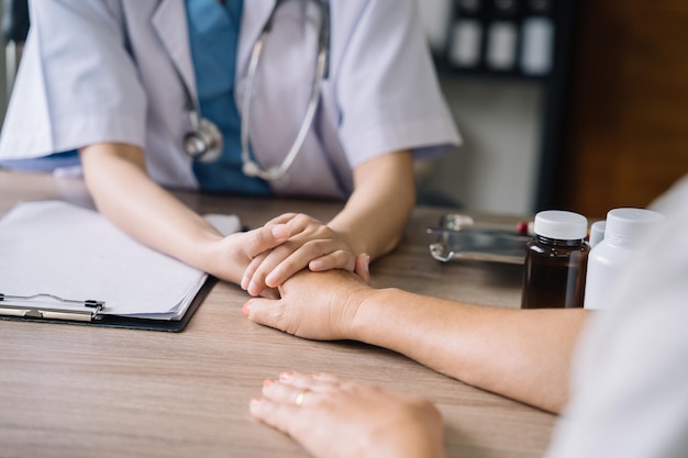 Le dottoresse si stringono la mano con i pazienti incoraggiandosi a vicenda per offrire preoccupazione e incoraggiamento d'amore mentre controllano il concetto di medicina della salute del paziente