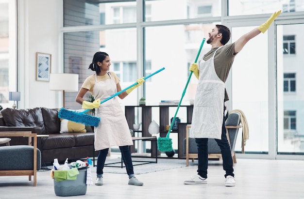 Le faccende domestiche possono essere divertenti con quella giusta Inquadratura di una giovane coppia felice che si diverte mentre lava il pavimento a casa