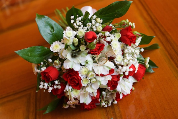 Le fedi nuziali si trovano su un bouquet da sposa di fiori diversi