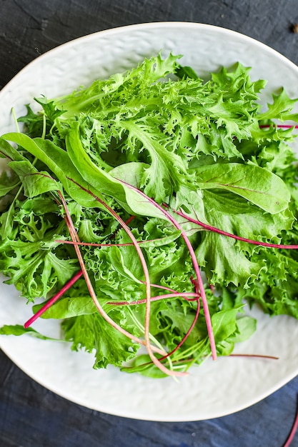 Le foglie di insalata verde mescolano le verdure che servono dimensioni