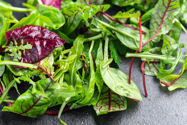 Le foglie verdi dell'insalata mescolano lo spuntino succoso microgreen pronto da mangiare sul tavolo vista dall'alto del pasto sano