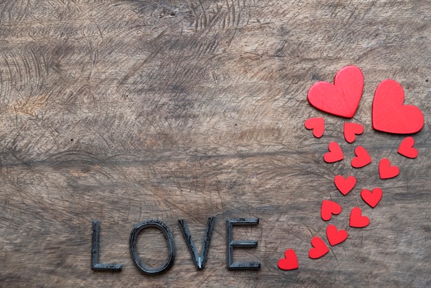 Le forme rosse del cuore su fondo astratto nel concetto di amore per il giorno di biglietti di S. Valentino
