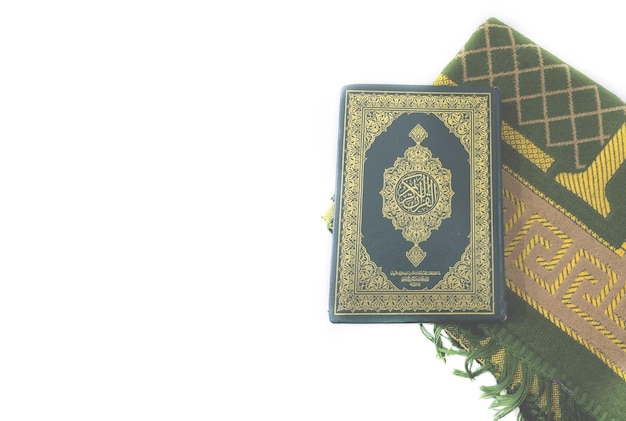 Le foto del Corano e i tappeti da preghiera in arabo sulla copertina sono tradotte come Corano
