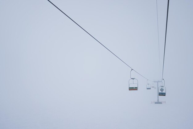 Le funivie sono appese ai cavi in una nebbia silenziosa