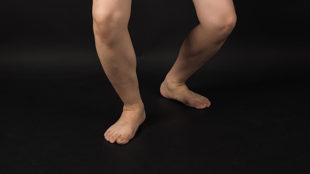 Le gambe dell'uomo asiatico e l'accorciamento a piedi nudi sono isolati su sfondo nero