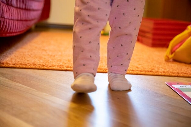 le gambe di un bambino piccolo camminano per la stanza. concetto di primi passi del bambino. senza volto. felice genitorialità