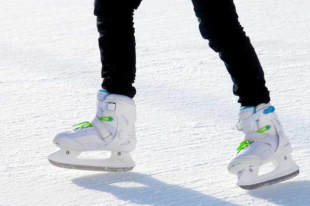 Le gambe di un uomo che pattina sulla pista di pattinaggio. Sport e divertimento. Riposo e vacanze invernali.