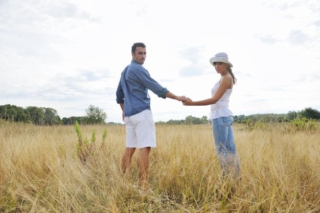 le giovani coppie felici hanno tempo romantico all'aperto mentre sorridono e si abbracciano