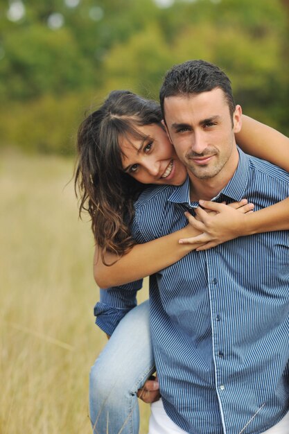 le giovani coppie felici hanno tempo romantico all'aperto mentre sorridono e si abbracciano