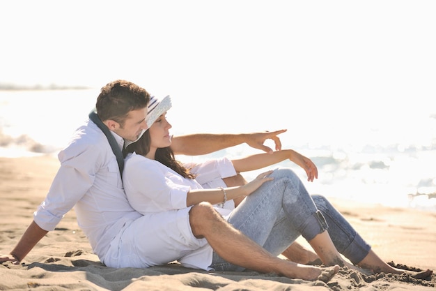 le giovani coppie felici in abiti bianchi hanno una ricreazione romantica e si divertono sulla bellissima spiaggia in vacanza