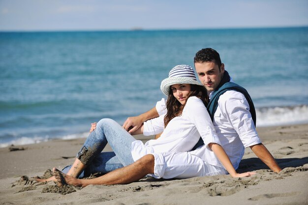 le giovani coppie felici in abiti bianchi hanno una ricreazione romantica e si divertono sulla bellissima spiaggia in vacanza