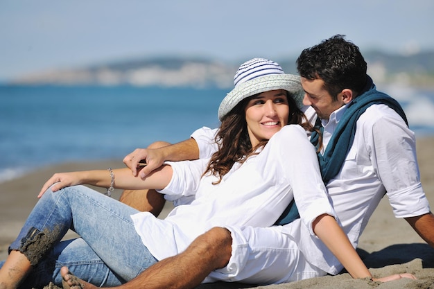 le giovani coppie felici in abiti bianchi hanno una ricreazione romantica e si divertono sulla bellissima spiaggia in vacanza