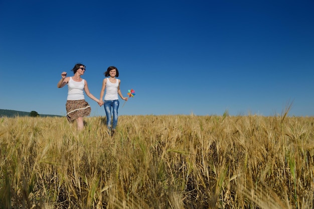 le giovani coppie felici innamorate hanno romanticismo e divertimento al campo di grano in estate