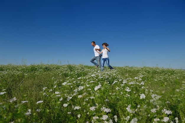 le giovani coppie felici innamorate hanno romanticismo e divertimento al campo di grano in estate