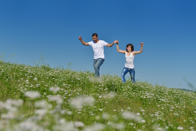 le giovani coppie felici innamorate hanno romanticismo e divertimento al campo di grano in estate