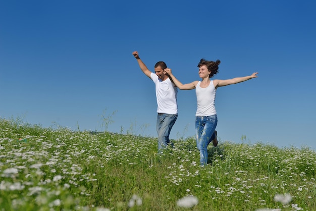 le giovani coppie felici innamorate hanno romanticismo e divertimento al campo di grano in estate