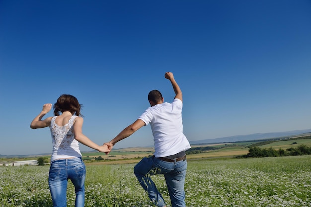 le giovani coppie felici innamorate hanno romanticismo e divertimento al campo di grano in estate