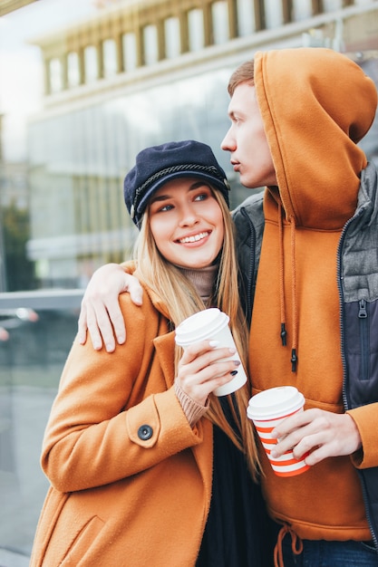 Le giovani coppie felici negli amici degli adolescenti di amore si sono vestite nello stile casuale che camminano insieme sulla via della città nella stagione fredda