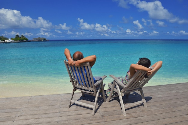 le giovani coppie felici si divertono e si rilassano durante le vacanze estive sullo sfondo Maldive posizione di viaggio e bellissima spiaggia di sabbia bianca