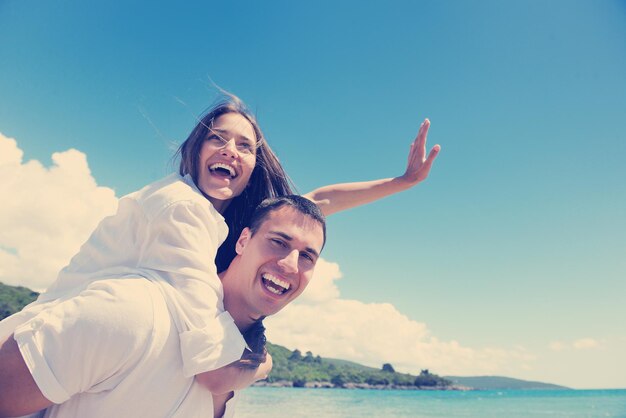 le giovani coppie romantiche felici innamorate si divertono a correre e rilassarsi sulla bellissima spiaggia