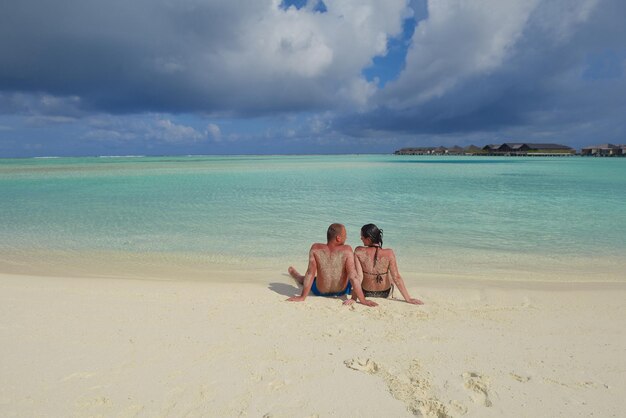 le giovani coppie romantiche felici innamorate si divertono a correre e rilassarsi sulla bellissima spiaggia