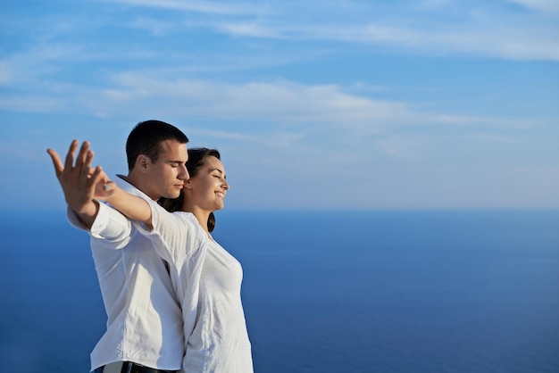 le giovani coppie romantiche felici si divertono a rilassarsi sorridendo al balcone della terrazza all'aperto della casa moderna