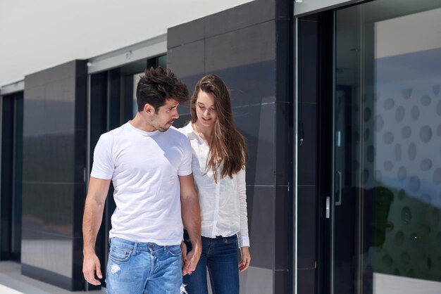 le giovani coppie romantiche felici si divertono a rilassarsi sorridendo alla terrazza del balcone all'aperto della casa moderna