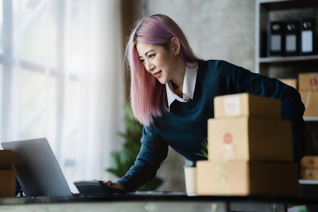 Le giovani donne asiatiche lavorano in ufficio per controllare il prodotto nel concetto di magazzino e commerce