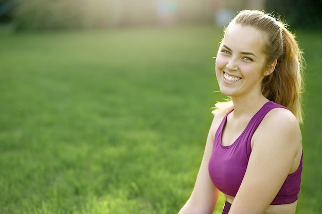 Le giovani donne felici sono sedute nello sport del parco