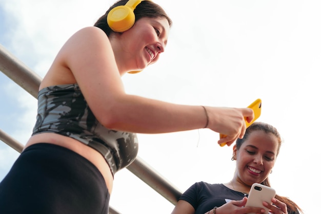 Le giovani donne scelgono la musica prima di fare jogging in città