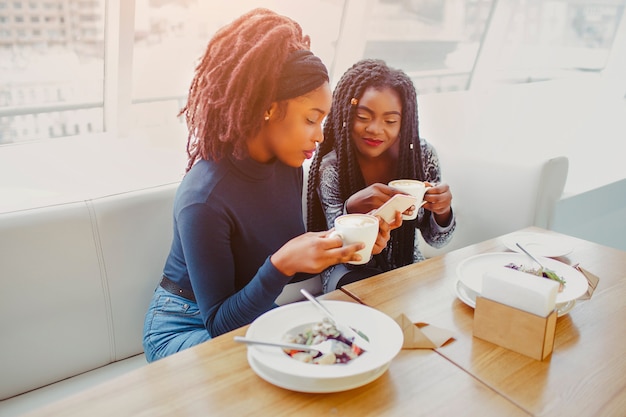 Le giovani donne serie si siedono in caffè