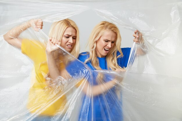 Le giovani donne si offrono volontarie nella campagna di magliette gialle e blu contro l'uso di polietilene e plastica. Concetto di riciclaggio dei rifiuti