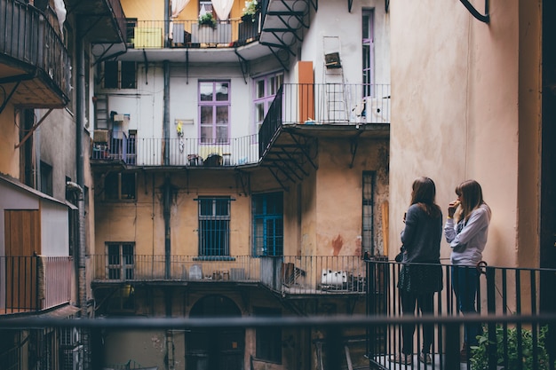 Le giovani donne stanno insieme nel patio e lo guardano