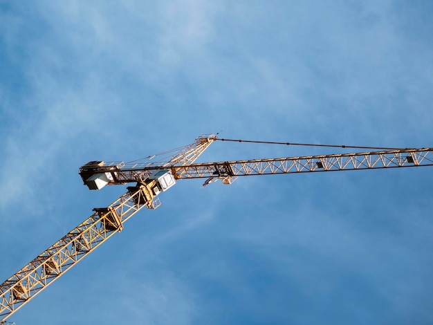 Le gru da costruzione in alto nel cielo con le nuvole coperte