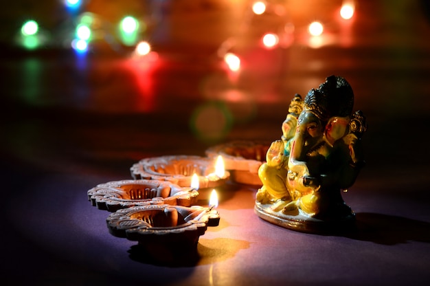 Le lampade di diya di argilla illuminate con Lord Ganesha durante la celebrazione di Diwali. Biglietto d'auguri Design Indian Hindu Light Festival chiamato Diwali