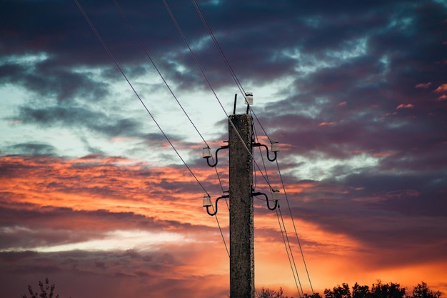 Le linee elettriche sovrastano la linea elettrica contro il cielo blu