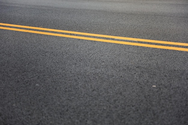 Le linee gialle sulle strade simboleggiano la separazione del traffico, la cautela e le zone di non parcheggio che migliorano la strada.