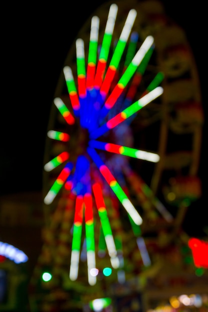 Le luci al neon sulla ruota panoramica nel parco di divertimenti