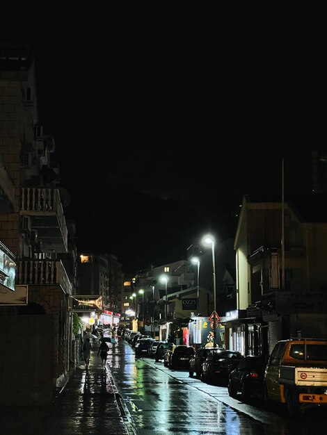 Le macchine sono parcheggiate lungo la strada di una piccola città vicino alle case