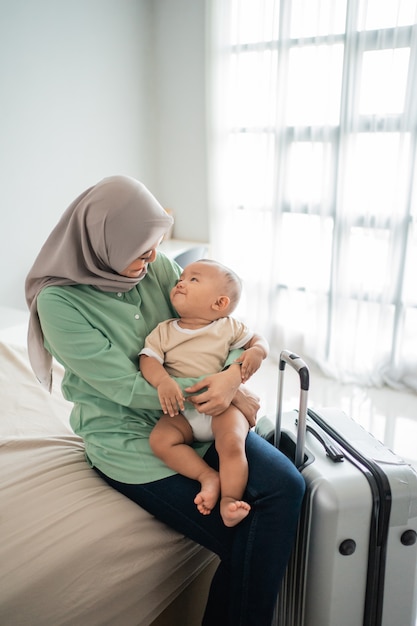 Le madri musulmane portano i loro bambini seduti sul letto