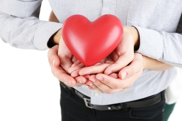 Le mani amano il cuore della holding delle coppie isolato su bianco