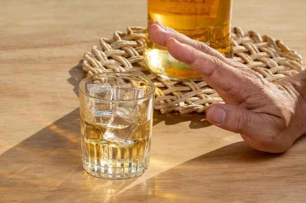 Le mani bloccano a catena un bicchiere di whisky per smettere di bere. concetto di alcolismo. Smettere di bere dipendenza da alcol.