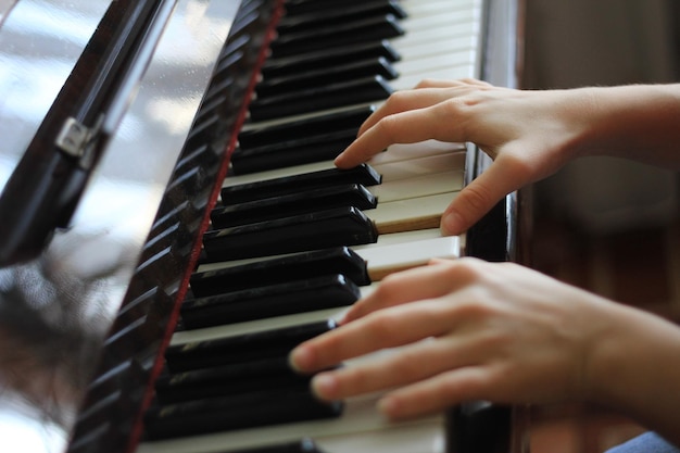 Le mani degli adolescenti suonano al pianoforte - concetto musicale, primo piano