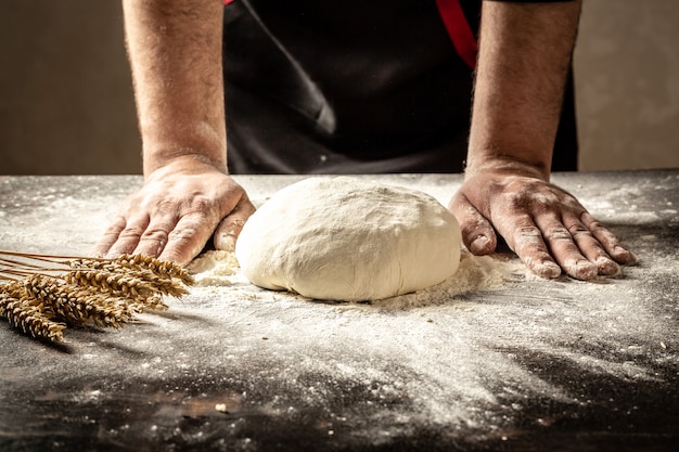 Le mani degli uomini impastano la pasta