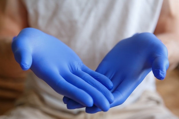 Le mani degli uomini in guanti medici blu stanno tenendo qualcosa. Gesti con le mani